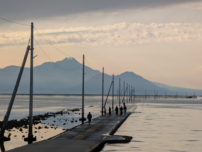 満潮時に海へ続く電柱群 長部田海床路